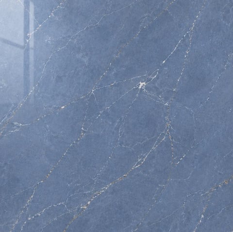 Dewy spider web with glistening water droplets on blue-gray surface